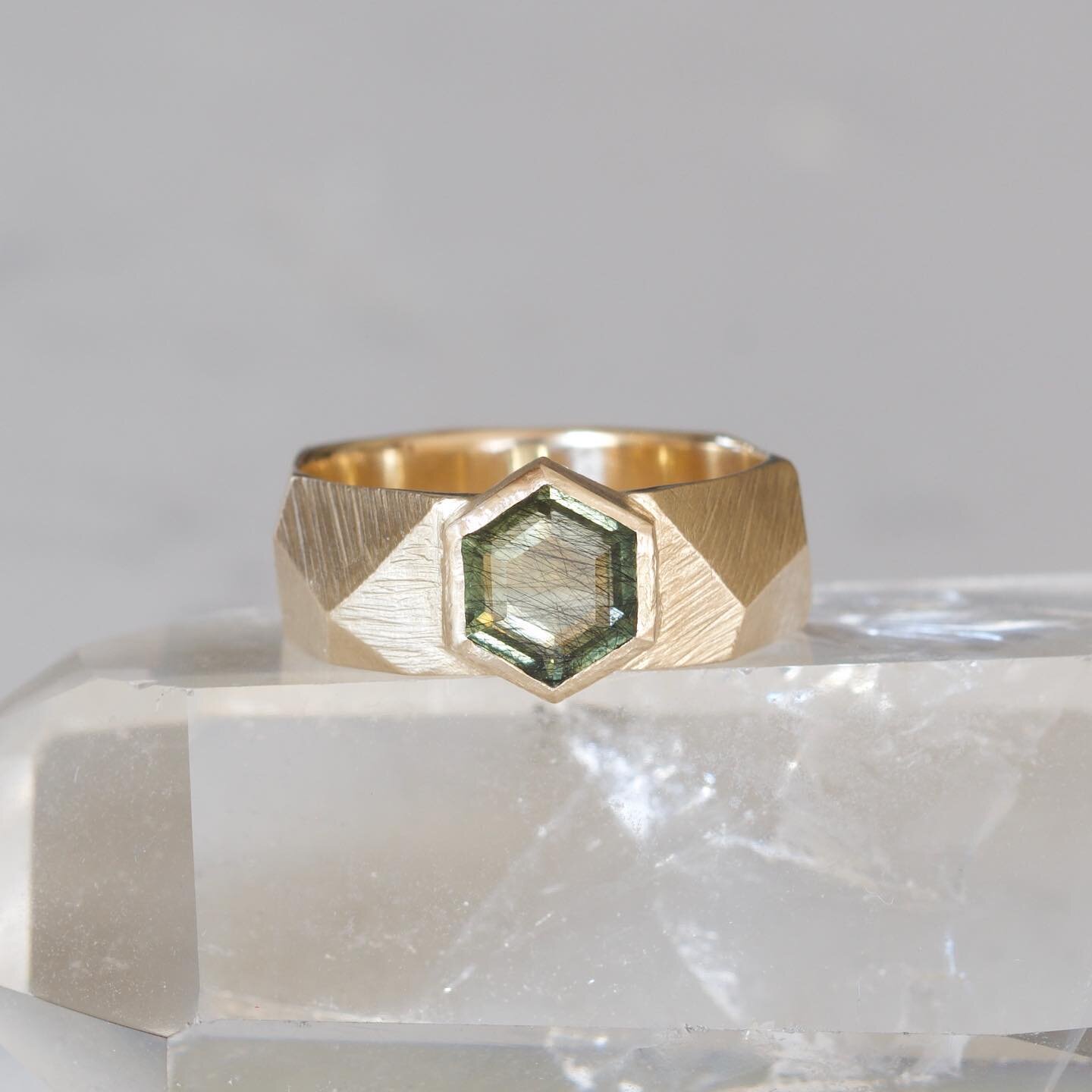 A truly epic and unique engagement ring, am I right? Our signature Geo Facet band design was the perfect complement to this very cool hexagonal peridot with ludwigite inclusions. Many thanks to Tiana of @hausofstones for this special gem! And congrat