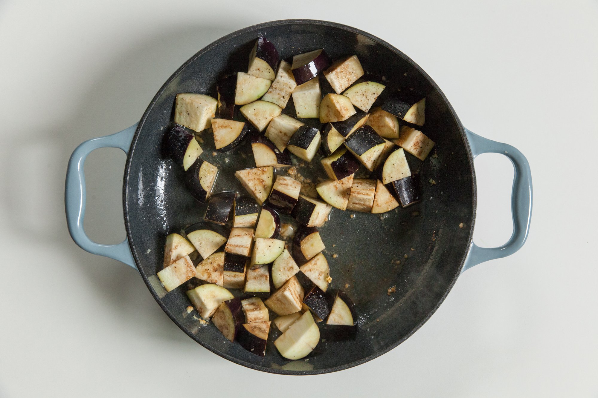  Chopped eggplant in pan on white background 