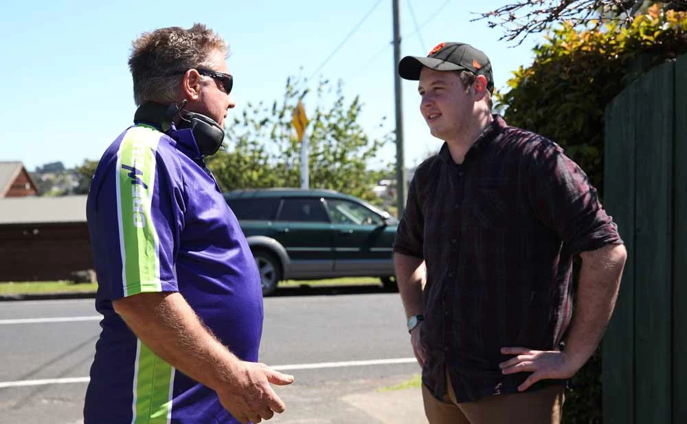 Crewcut business owner talks to his male client