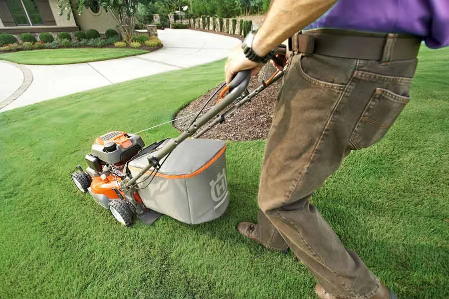 Man mowing perfectly manicured lawn