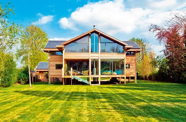This house in Berkshire, near the River Thames, was built on a plot that was prone to flooding every year and so the house was built on timber posts, to match the set requirements. Image Source: Homebuilding & Renovating