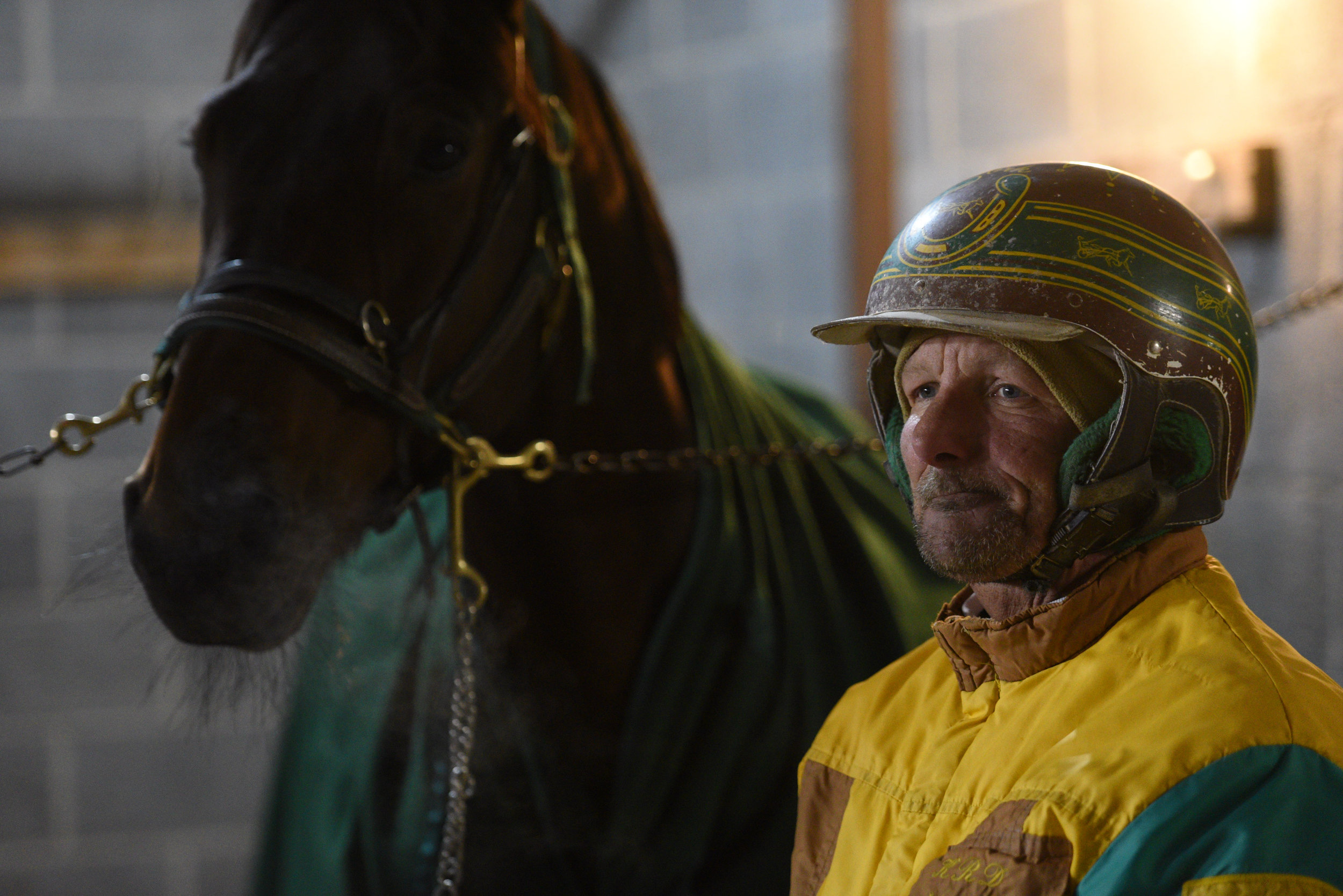 Kirk Desmond stands with a horse prior to the start of his next Harness race at Batavia Downs in Batavia, N.Y. on Nov. 10, 2017.