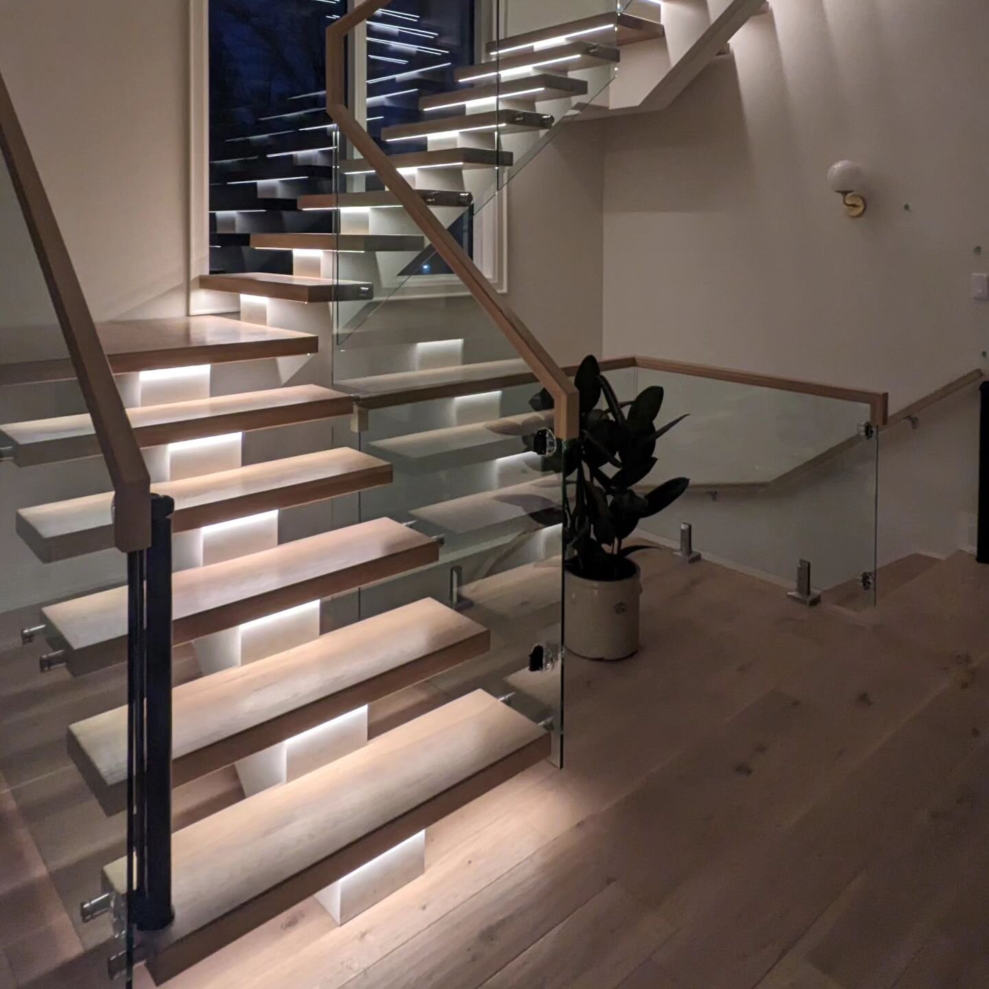 Feature stair with floating hardwood treads, glass rail and lighting. #stair #featurestair #hardwood #glass #glassrail #modern #contemporary #architecture #interior #design