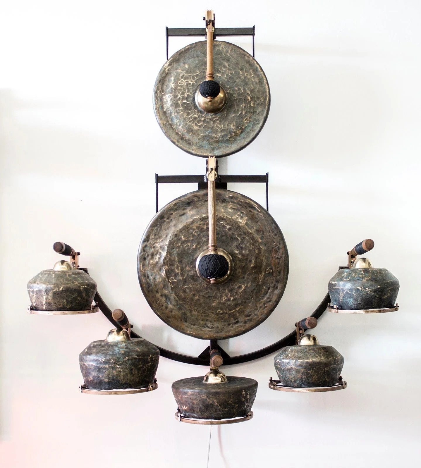 Gamelatron Lengkung Riak (Indonesian: Curved Ripple) 2017 7 Javanese Gongs patinated blue black with gold ripples, black patinated steel and silicon bronze mounting sculpture, bronze anodized and teak mallet robotic mechanisms, with physical computing system 47 x 17 x 54 in ( 119.38 x 43.18 x 137.16 cm )