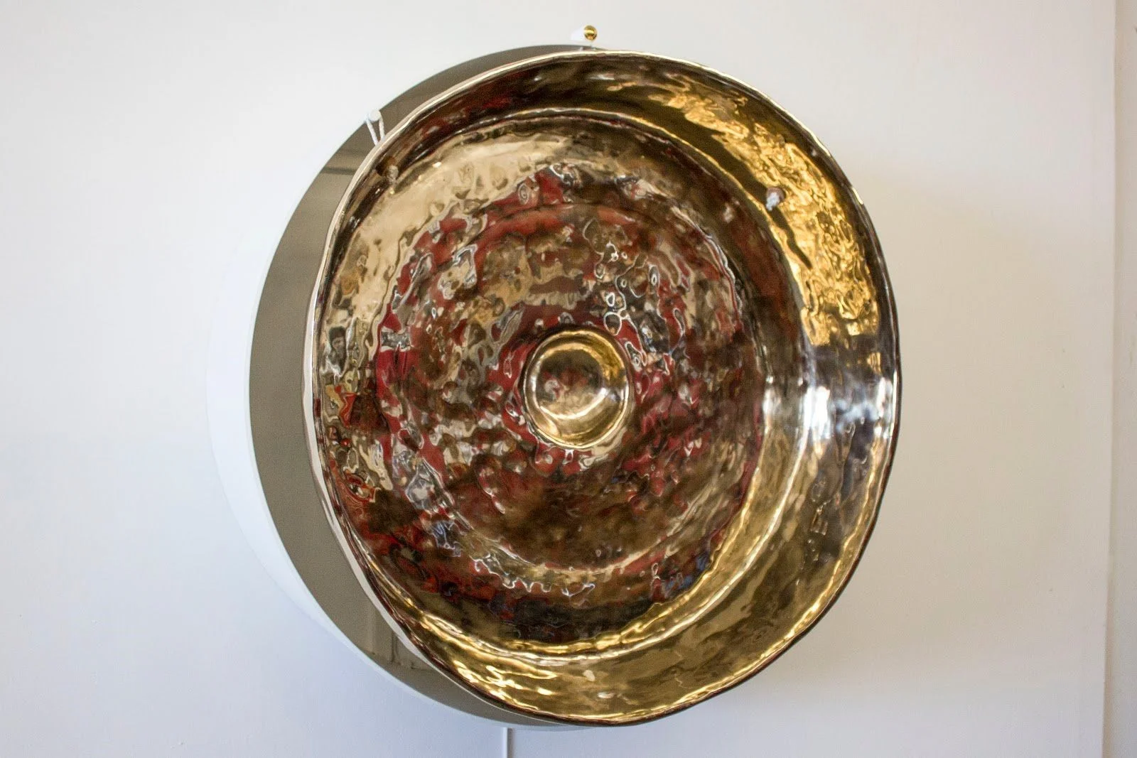 Single Tone Mindfulness Sculpture, 83hz 10 times to the heart 2017 Mirror polished patinated bronze convex gong, powder coated steel, digital relay switch 33 x 14 x 33 in ( 83.82 x 35.56 x 83.82 cm)
