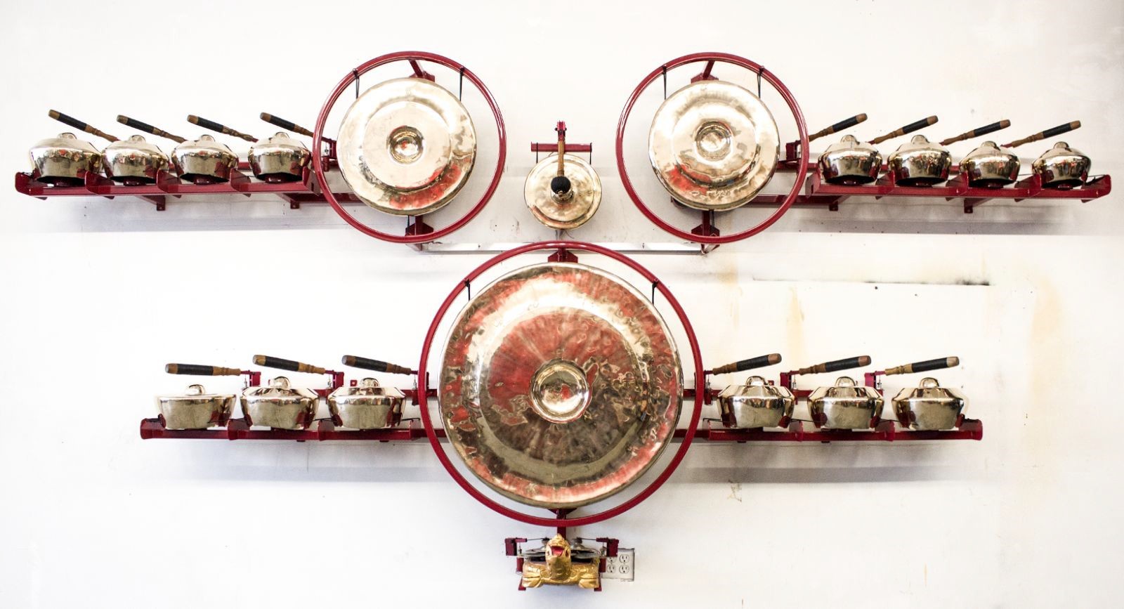 Gamelatron Gandaberunda (2-headed mythical creature) 2017 Mirror Polished Javanese Gongs, red powder coated steel with red anodized aluminum and teak wood robotic mechanisms, LED pucks, physical computing system 154 x 14 x 70 in ( 391.16 x 35.56 x 177.8 cm )