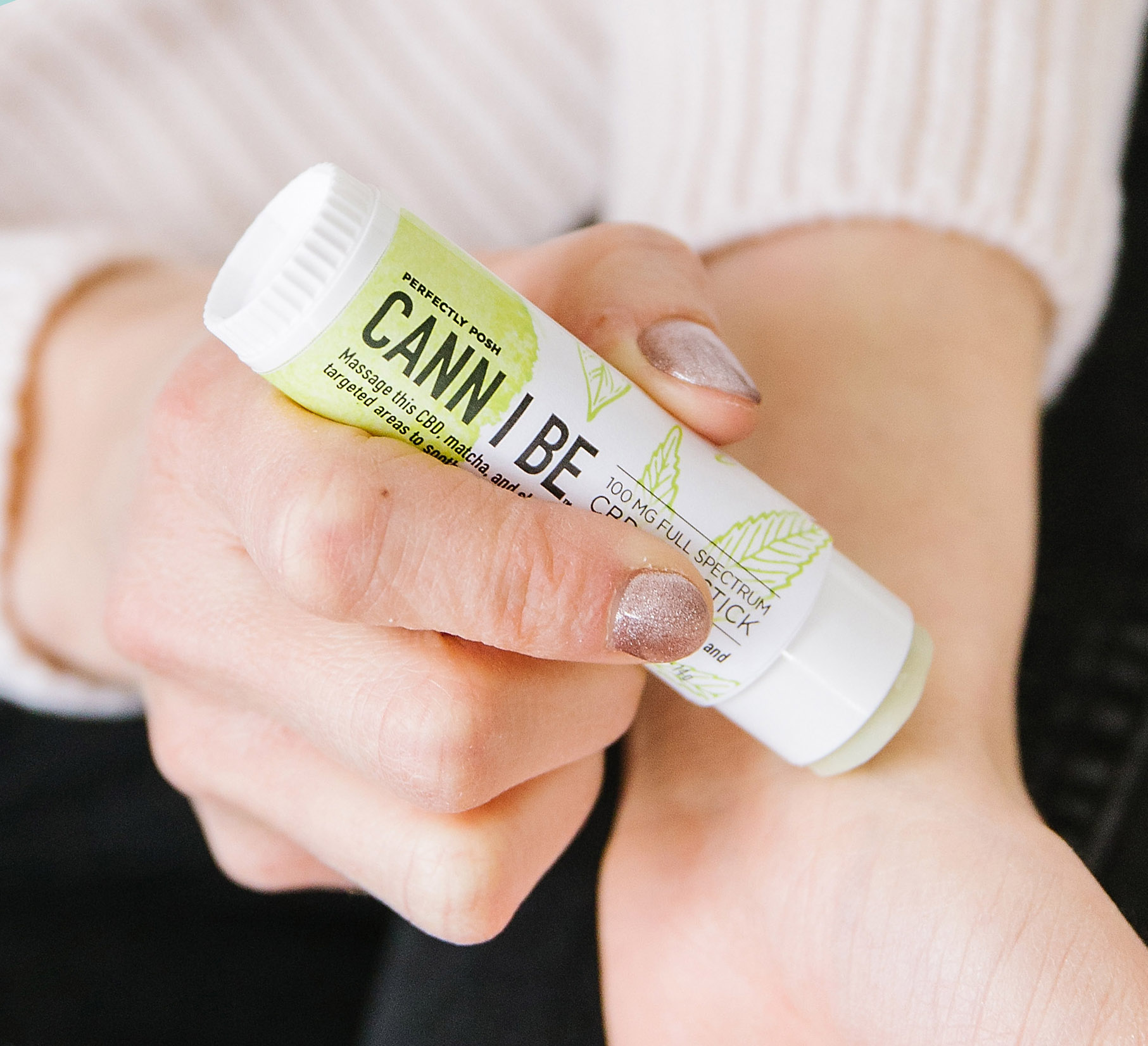Using Perfectly Posh Cann I Be 100 mg full-spectrum CBD oil Skin Stick on wrist, close up of Cann I Be Skin Stick