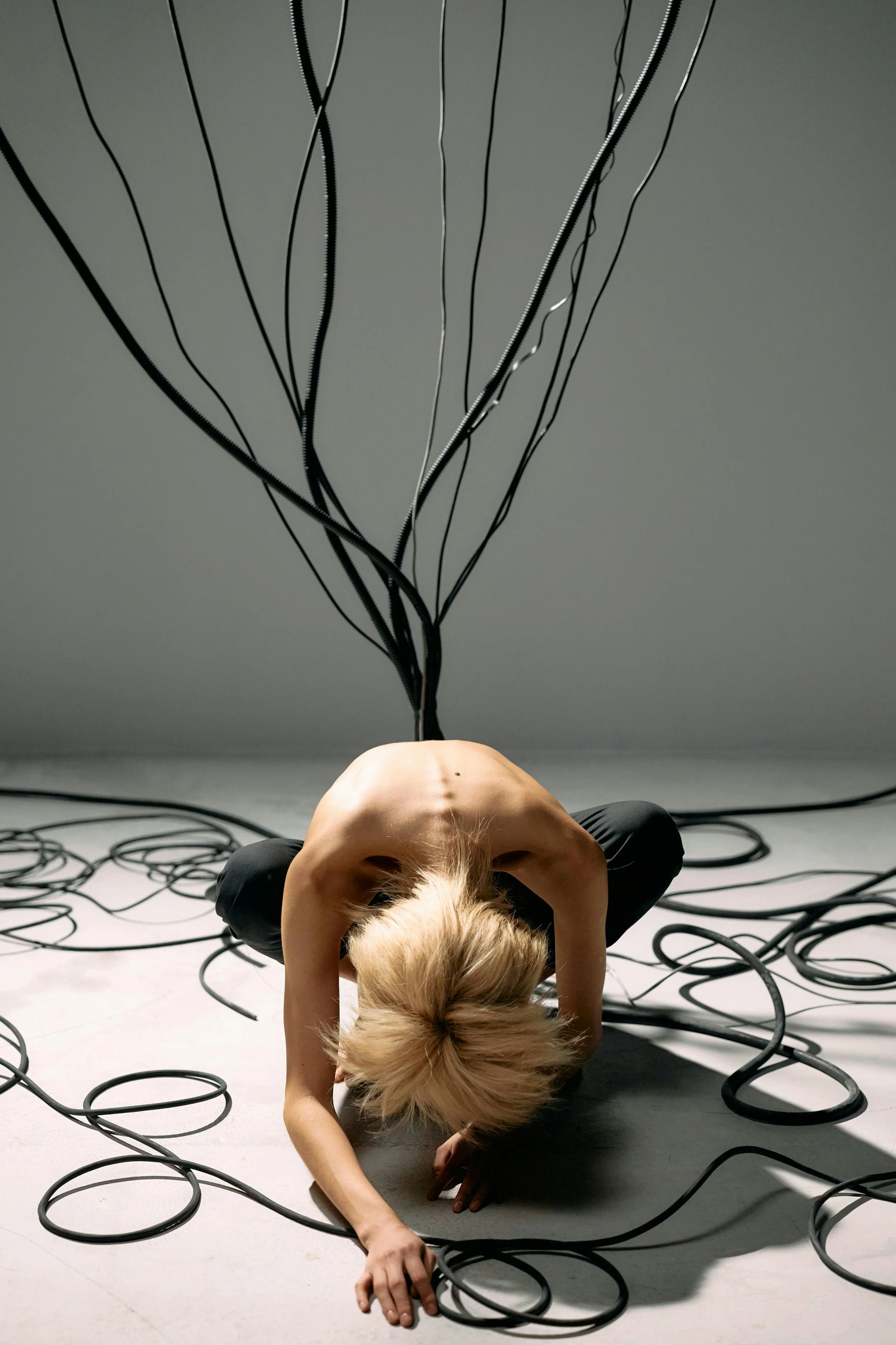 A person on the floor tangled in cables, plugged into a machine