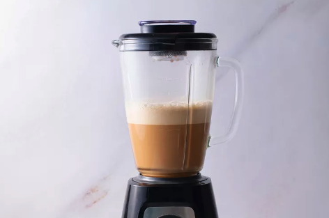 Bulletproof coffee blending in a blender until frothy