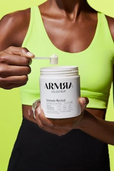 ARMRA colostrum powder scoop showing supplement use for gut health, immune support, and IBD digestive wellness