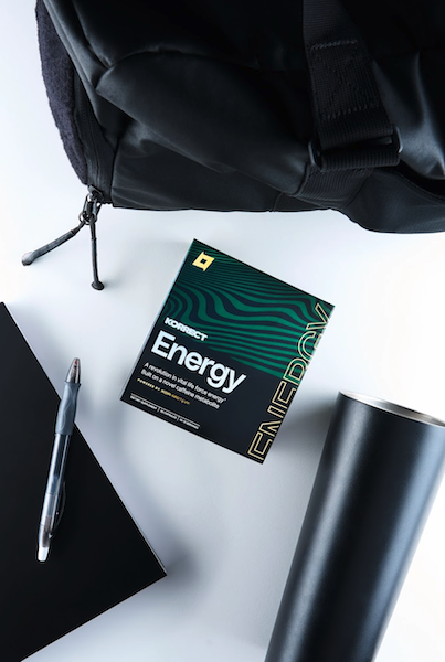 Korrect Energy supplement packet placed next to a backpack, notebook, and pen.