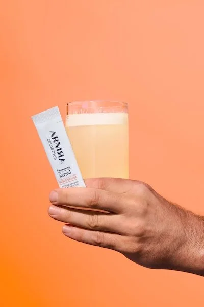 ARMRA colostrum stick pack mixed into a drink for immune support, gut health, and cold and flu recovery