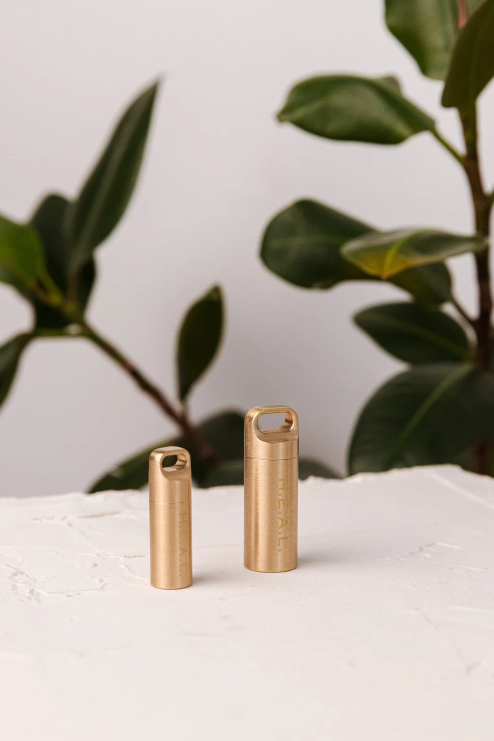 Two Leela H.E.A.L. capsules standing side by side, one slightly smaller than the other