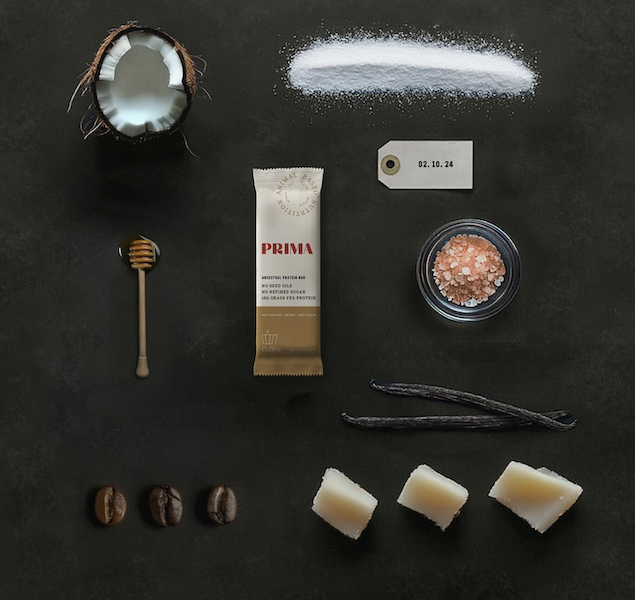 Prima protein bar with ingredients flat lay including coconut honey salt vanilla and clean ancestral protein bar components
