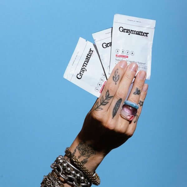 Hand holding Graymatter Bright Mind single serve sachets