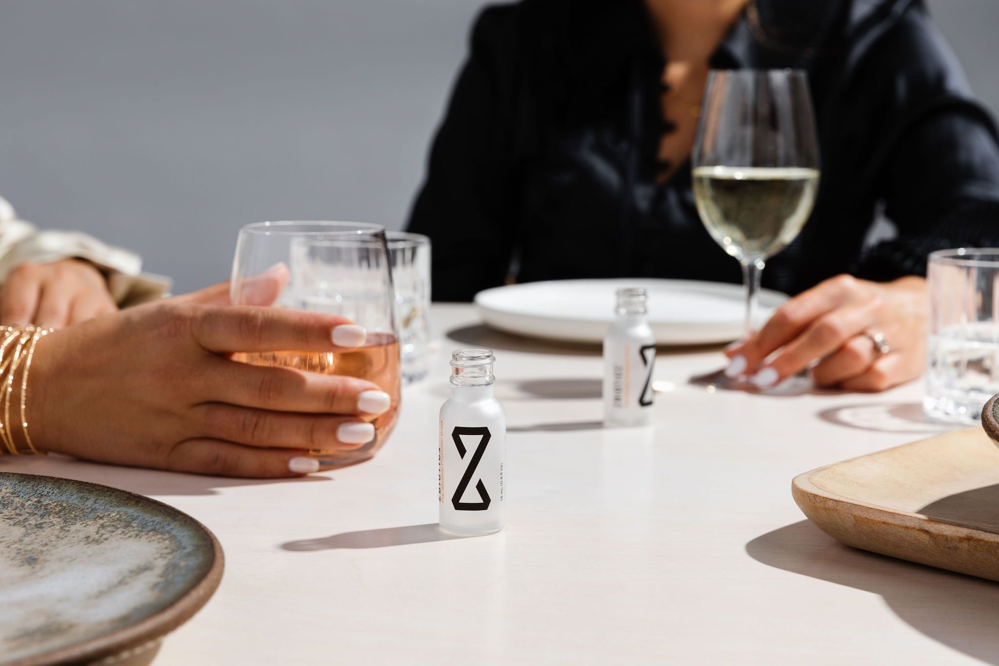 Wine glass and ZBiotics bottles on a dinner table