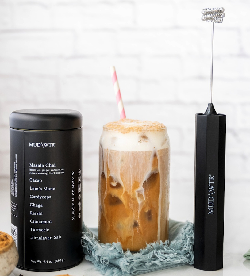 MUD/WTR tin next to an iced mud latte and a USB frother