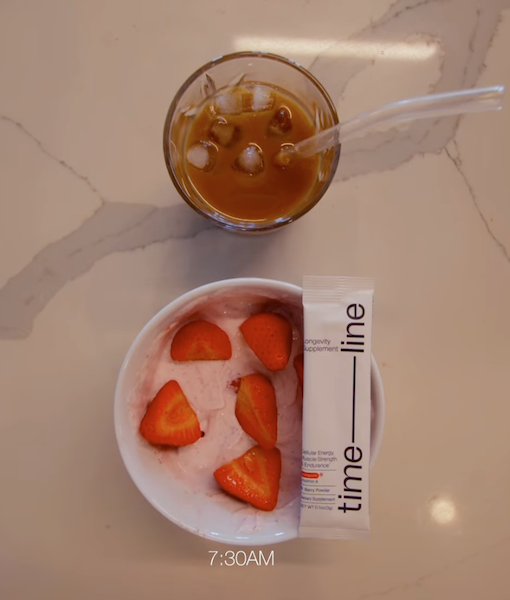 Mitopure urolithin A powder stick next to strawberry yogurt and iced coffee on kitchen counter