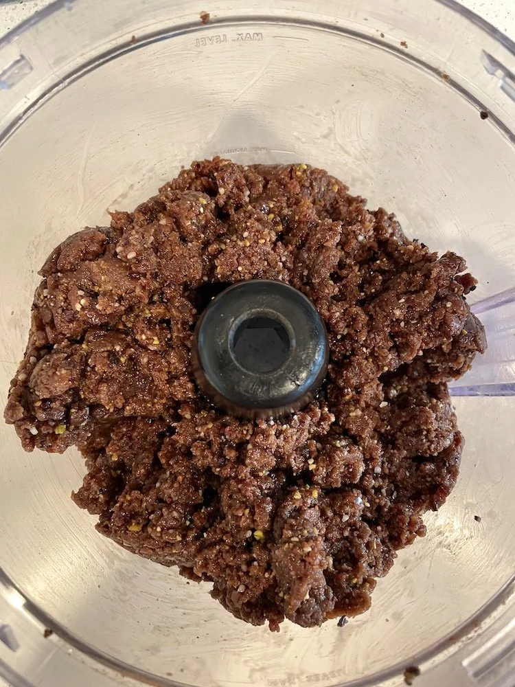 Date mixture and chopped nuts after pulsing into a sticky combined dough