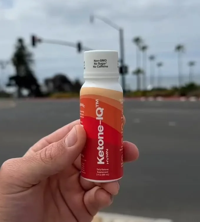 Hand holding a Ketone-IQ shot bottle outdoors