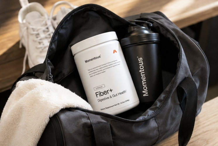 Momentous fiber supplement inside gym bag with shaker bottle for daily gut health routine and digestive support on the go