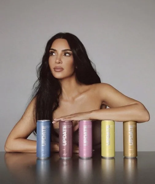 Model posing with Update Energy caffeine-free drink cans in multiple flavors