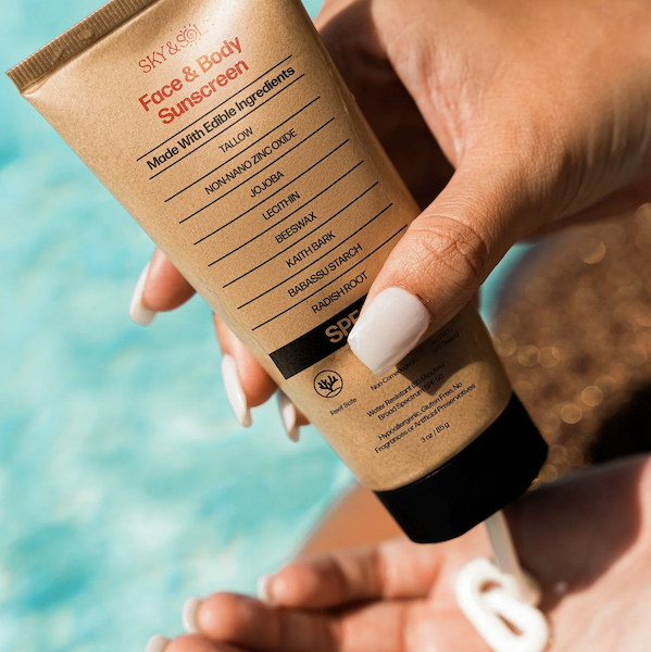 applying Sky and Sol tallow sunscreen at the beach showing non-toxic, mineral SPF for clean sun protection and daily skincare
