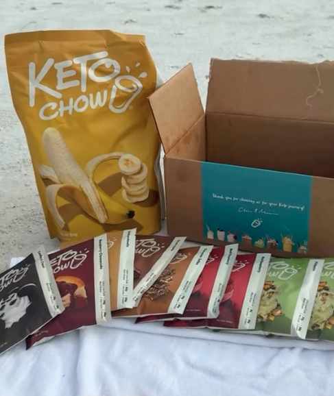 Unboxed Keto Chow order showing a bulk banana flavor bag, variety sample packets, and shipping box