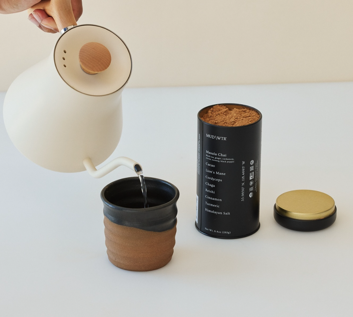 MUD/WTR tin, lid, and a mug being poured with hot water in the morning