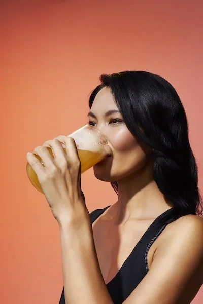 woman drinking ARMRA colostrum beverage for gut health and digestive support