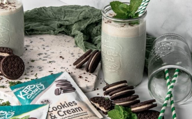 Keto Chow Cookies and Cream shake in a glass jar with mint and Oreo cookies on a marble counter