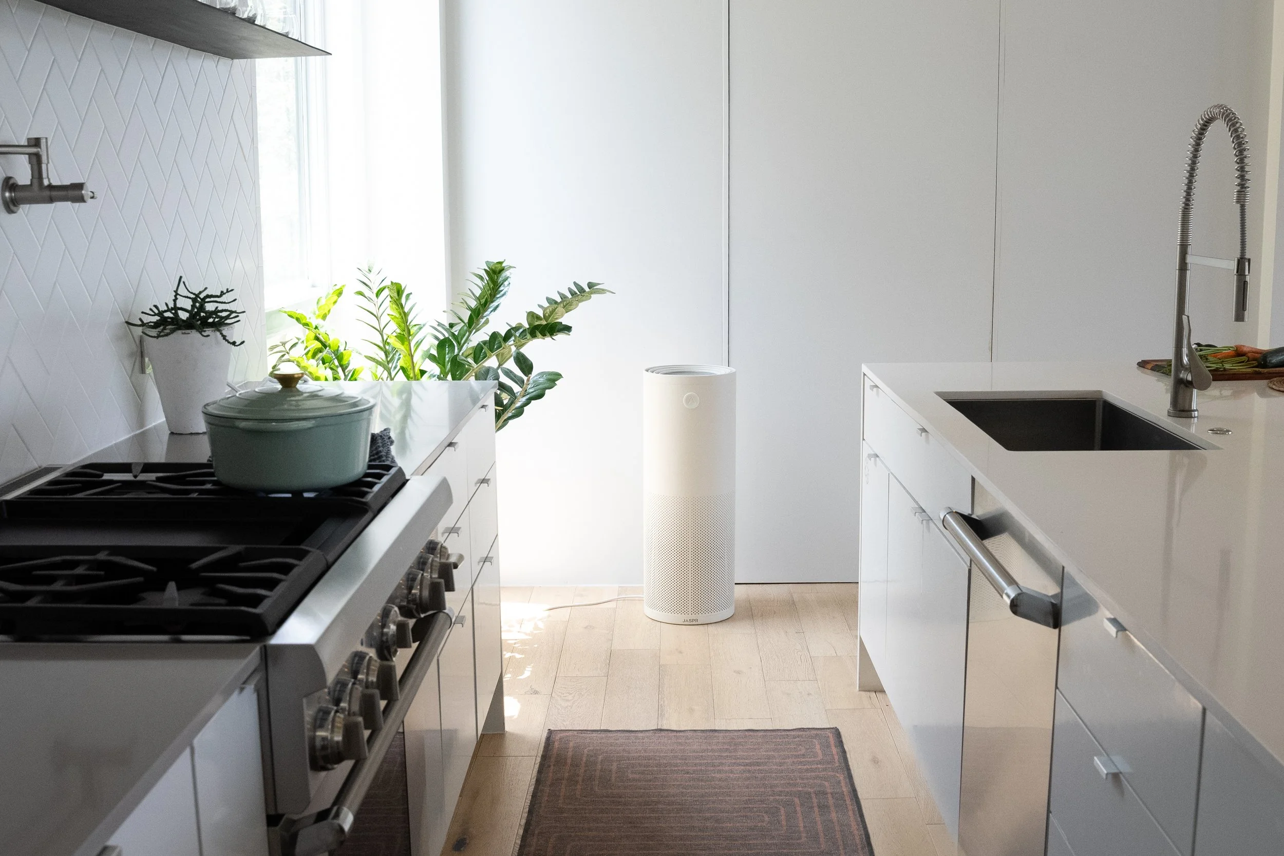 JASPR Air Purifier placed in a modern kitchen near a window, showing its full size and minimalist design in a home setting.