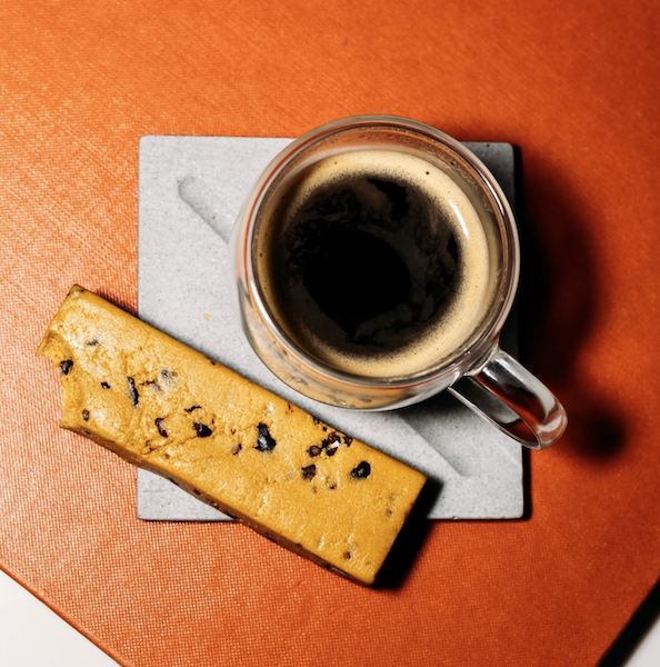 Prima protein bar next to a cup of espresso, shown as part of a morning routine