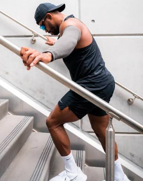 Wearing the Incrediwear Arm Sleeve during a workout, resting on stairs mid training