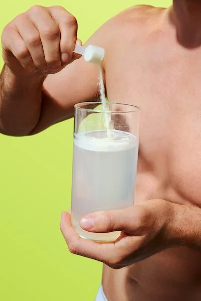 mixing ARMRA colostrum powder into water for gut health and immune support