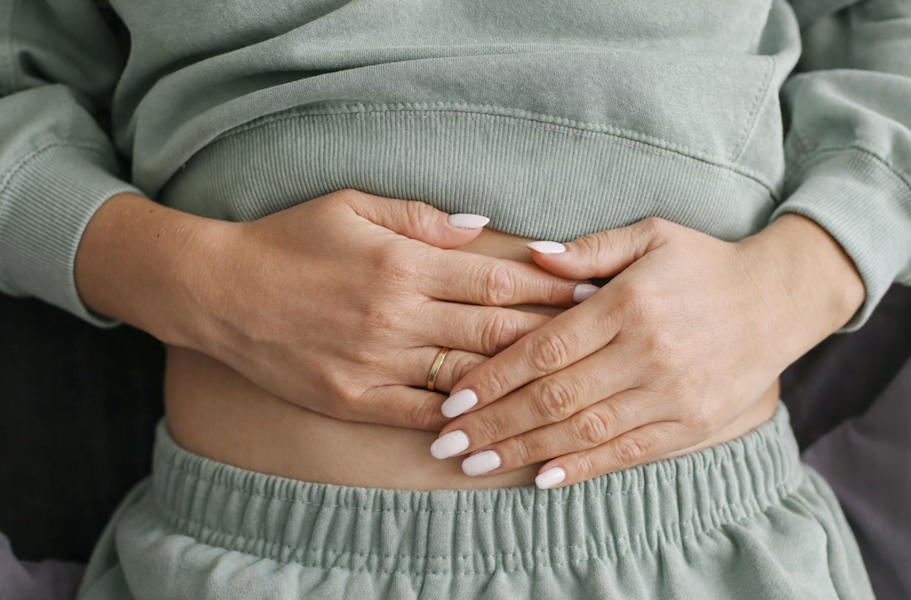 Person holding their stomach to represent gut health and digestive healing, commonly associated with BPC-157 support for leaky gut and intestinal repair.
