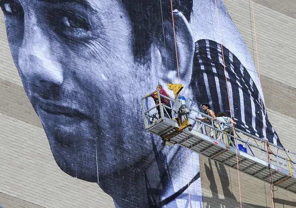 JR installing work for Philadelphia’s “Open Source” series. Photo: Michael Pronzato, courtesy the Philadelphia Inquirer .