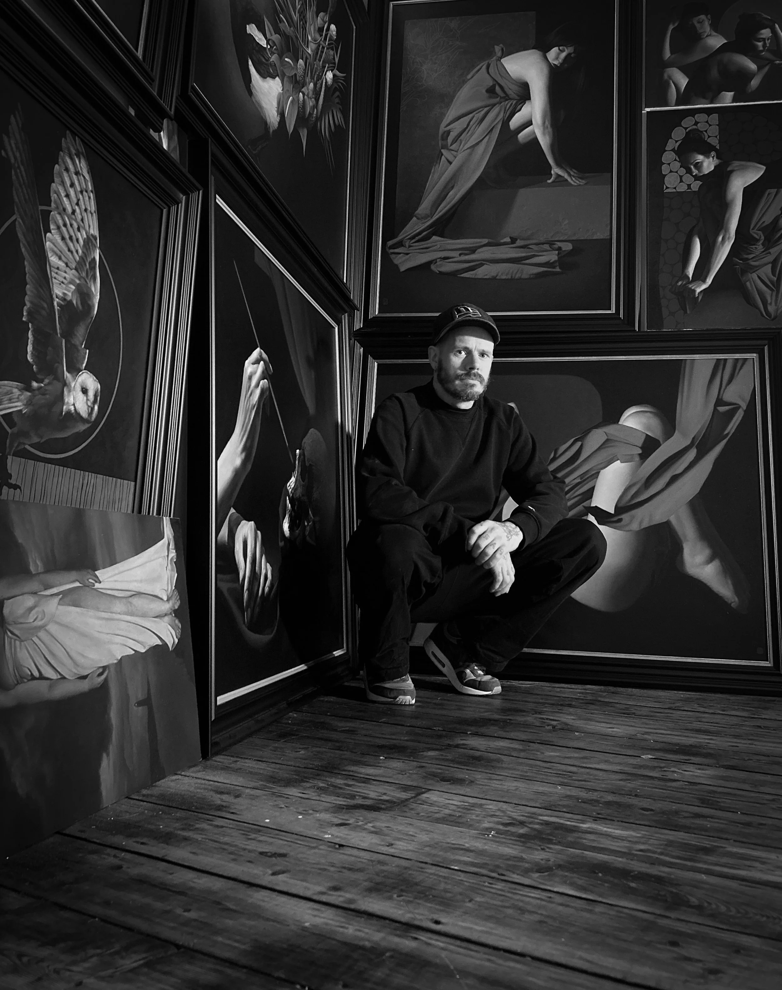 Photo of british figurative oil painter Dylan Lisle in his art studio with framed oil baroque style oil paintings