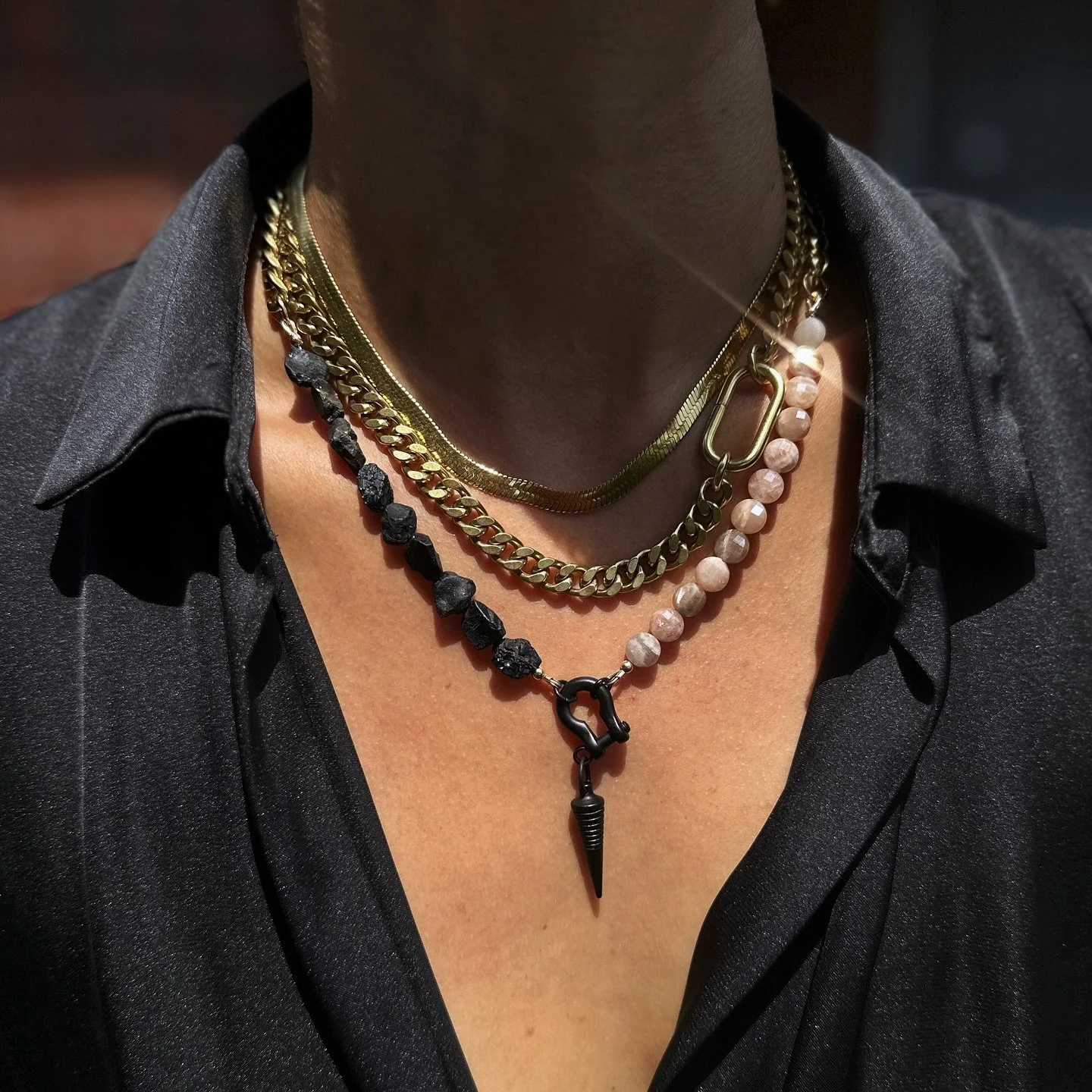 The perfect balance of edge and play. Our Most Wanted Race Track necklace meets the new Matte Black Shackle layered with Raw Spinel and Peach Moonstone, a pairing that defines statement styling for the season. 

Explore both styles via link in bio.

