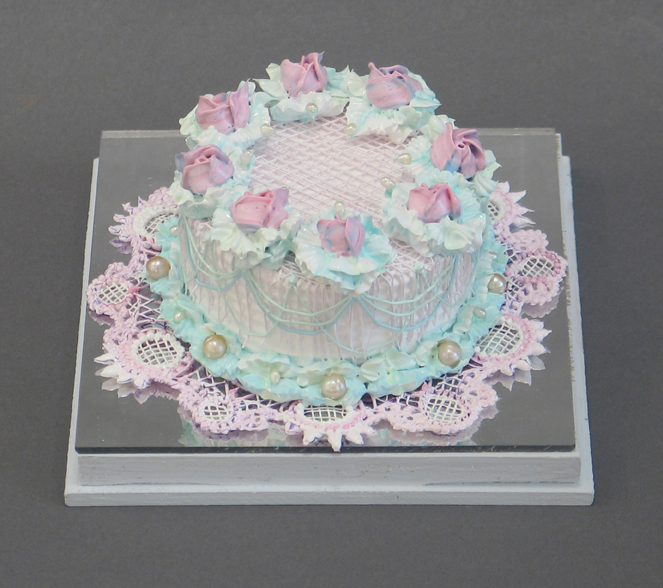Acrylic pink cake with pink flowers on top and pearls