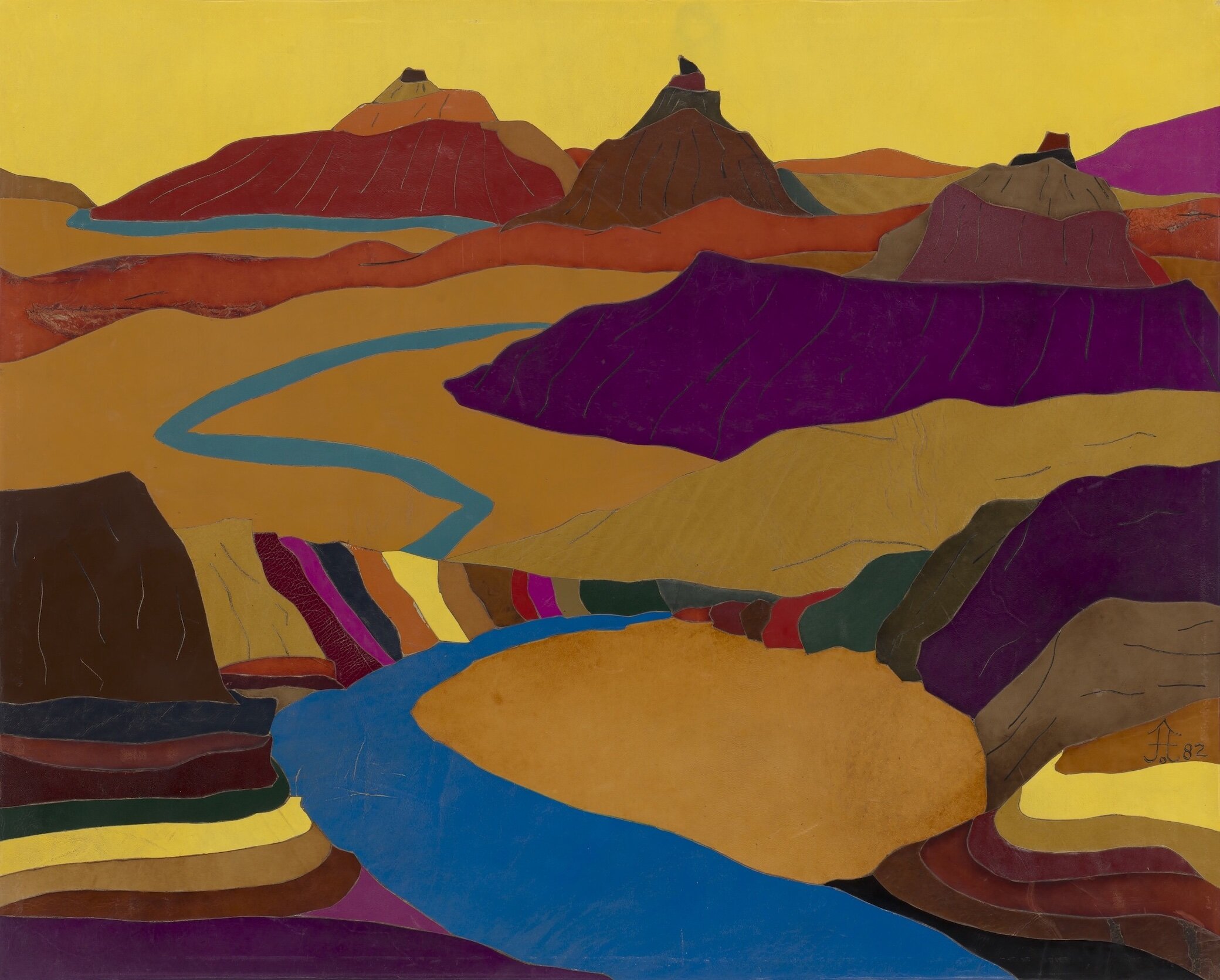 Scene of a blue river meandering through a multicolored, mountainous desert landscape.