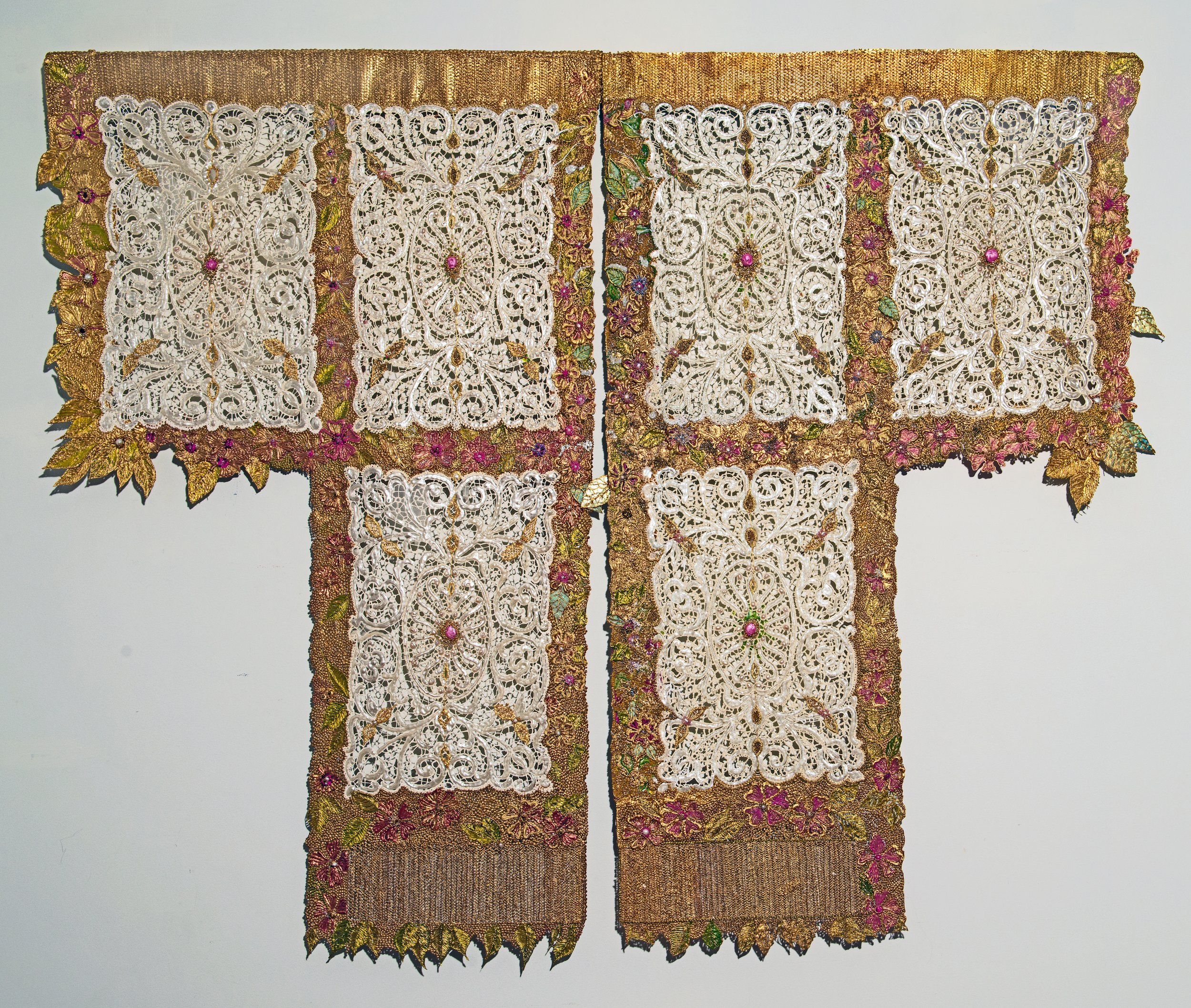 Double panel garment of acrylic paint lace, flowers, and leaves in white, gold, pink, and green.