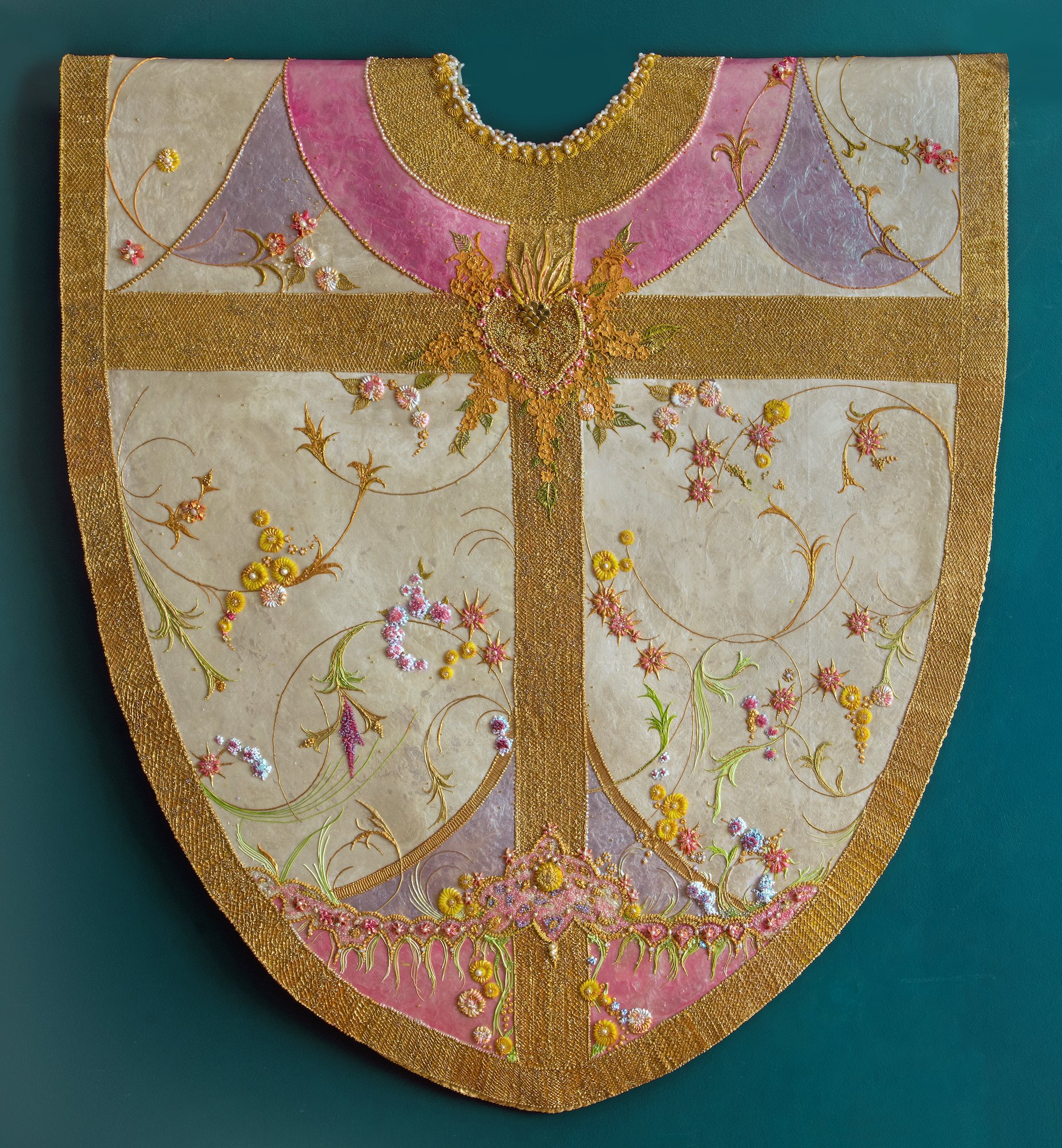 Vestment in pink, gold, white, and purple in paint.