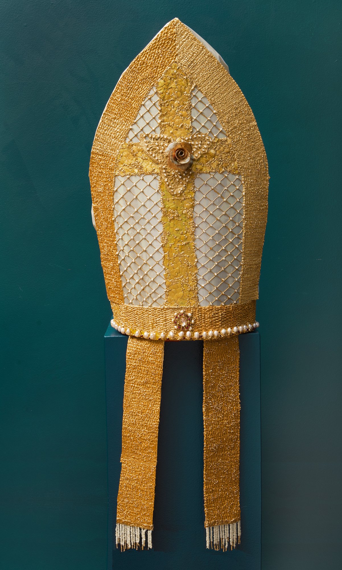 Back of a gold and silver mitre adorned with pearls, beads, and a rose.
