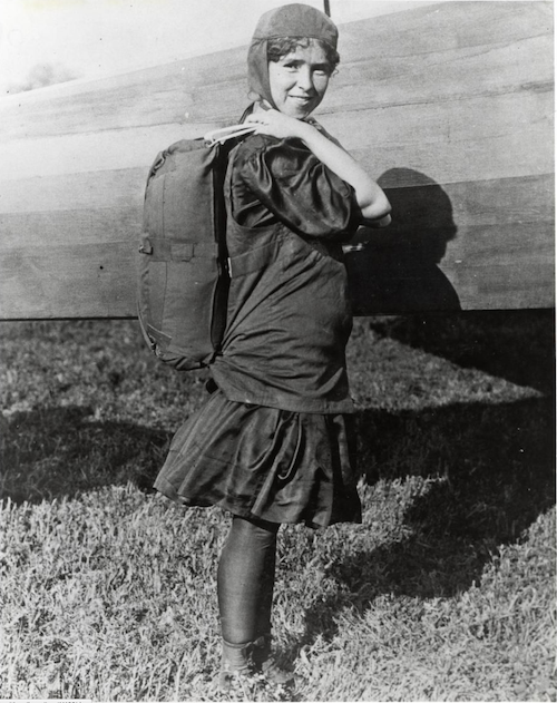 Tiny Broadwick posed beside a plane in flying gear, with parachute, circa 1912. Via the Smithsonian National Air and Space Museum.