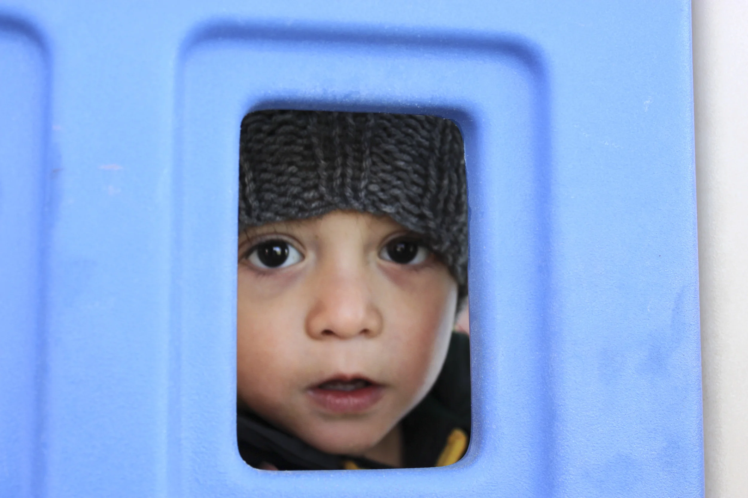 Adalino looks out the window of a children’s playhouse during recess at CLNKids on Nov. 26, 2014.