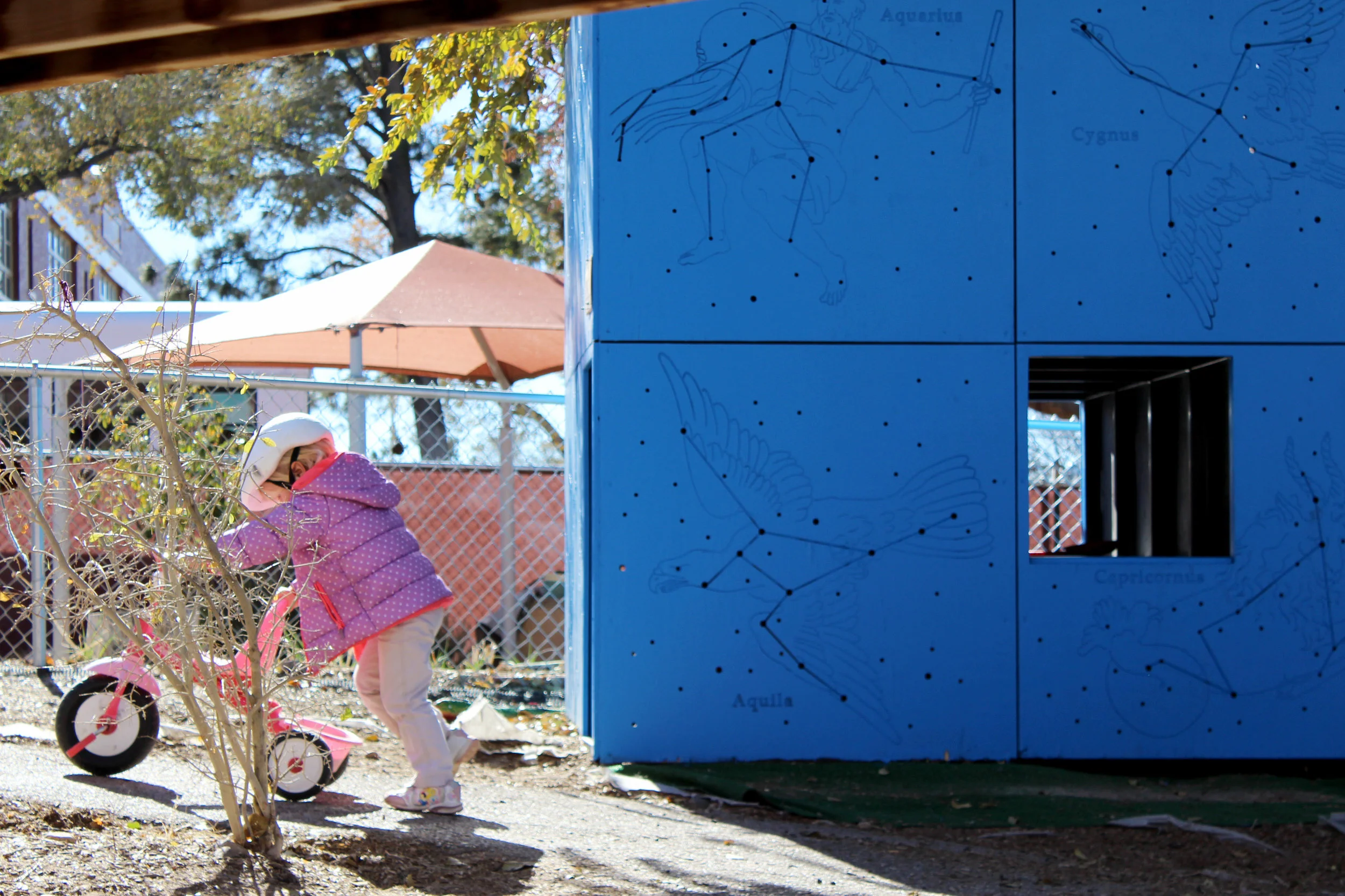 Ruby’s eldest sister pushes her bike by a play house on Nov. 26, 2014.
