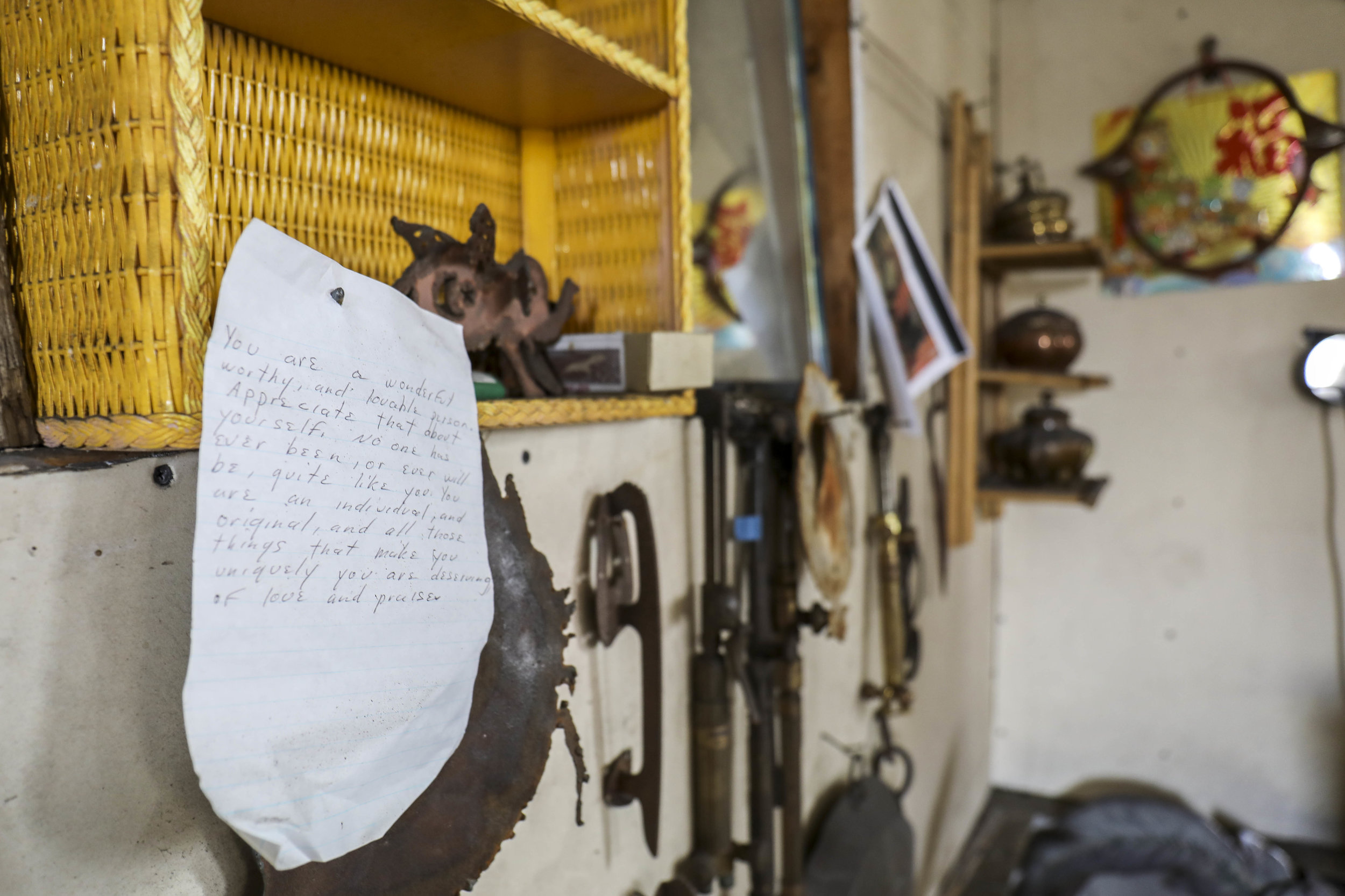 A wall decorated with items collected over the years, with a personal note to self at Stover's home metal shop where she creates her work.