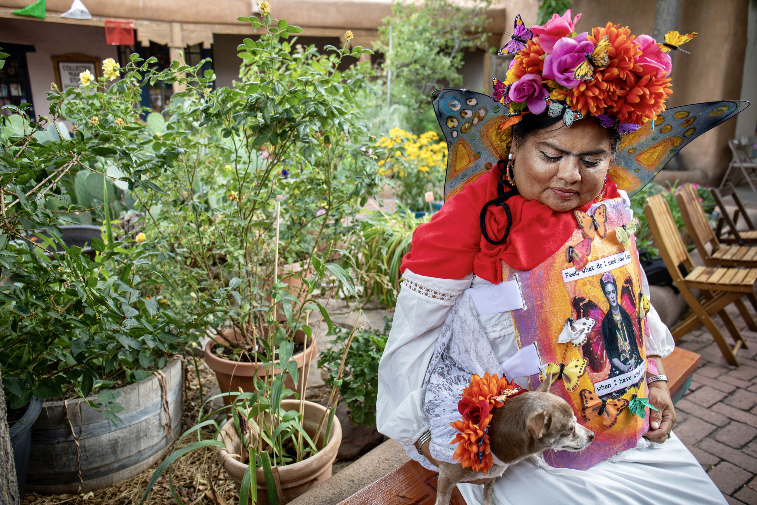 The annual Frida Kahlo Fiesta painted the dusty streets of Old Town in Frida Kahlo cheer on a rainy day in July. The event was hosted by Sally Moon of W!ld Moon Boutique. The event began nine years ago in celebration of Mexican artist Frida Kahlo whose birthday and passing occurred in July. According to Moon, Kahlo has always been her icon. “I admired her courage and her tenaciousness and nothing actually stopped her not even her death bed.” The event consists of a look alike contest, a birthday cake for Kahlo and a live band. Next year the event will celebrate its 10th anniversary. *Gina Two Feathers and her dog Koko Frida. Two Feathers was inspired by the butterfly motifs sometimes found in Kahlo’s paintings signifying rebirth. She took second place in the look alike contest.
