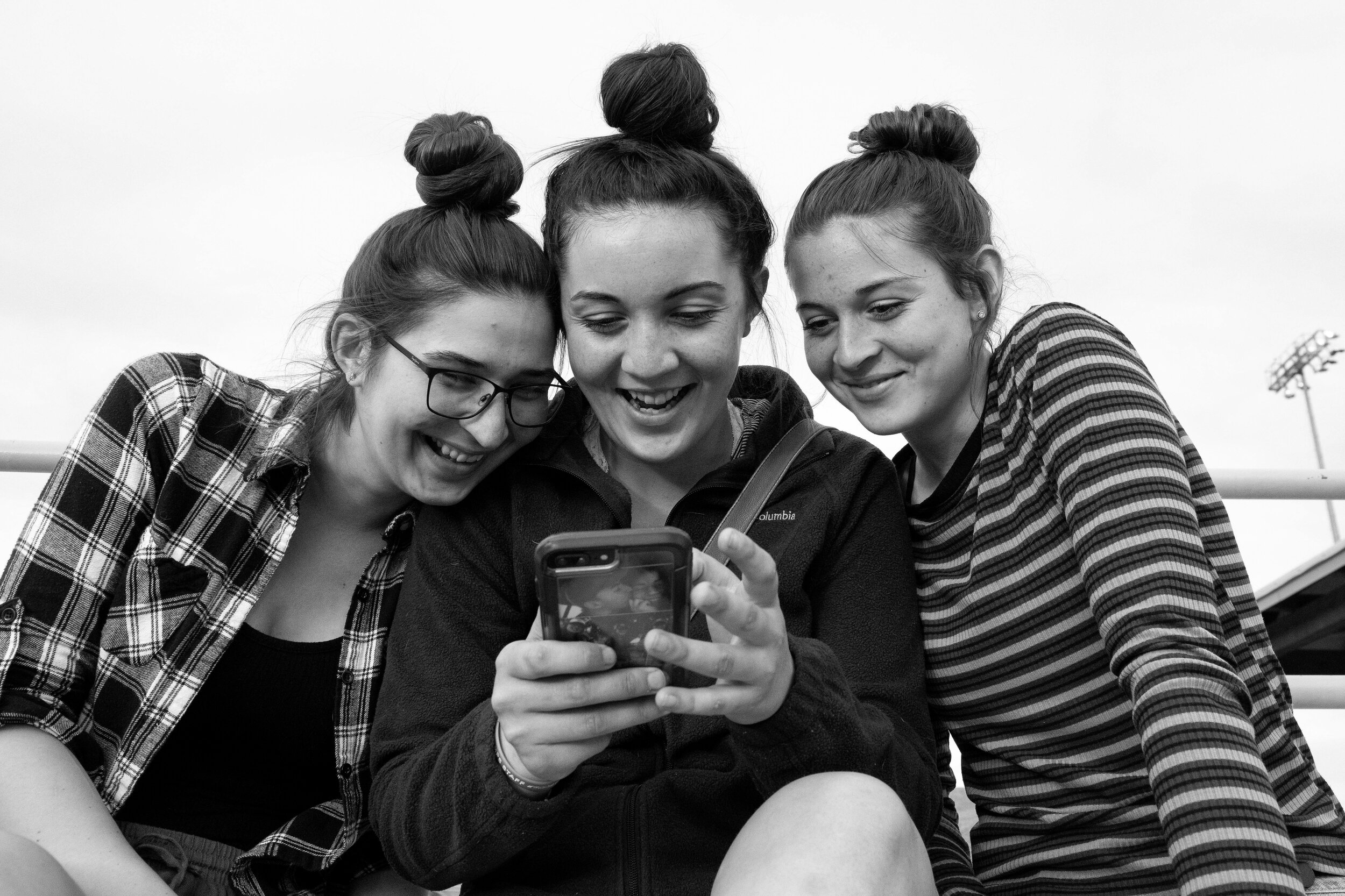  Sierra, middle, and her sisters laugh at their selfie during their little brother Zachary's baseball game Wednesday evening in Farmington, N.M. 